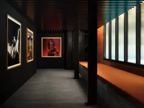 Apple Music A corridor featuring photos of artists including Olivia Dean on the wall